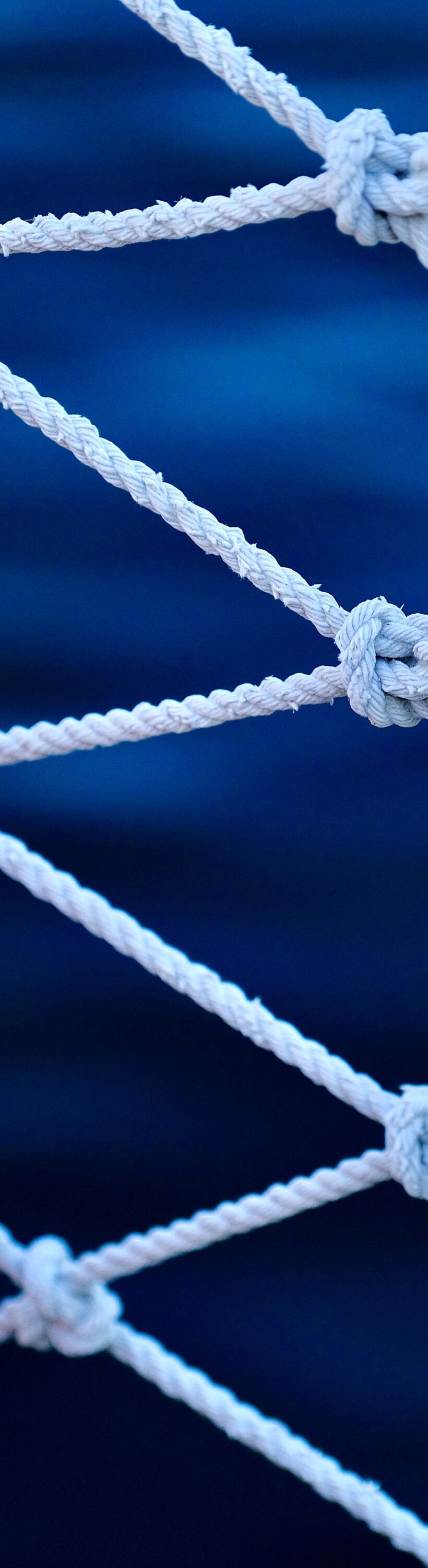 Geknuepftes Fischernetz Geknüpftes Fischernetz, dessen Maschen ein gleichmäßiges Muster bilden