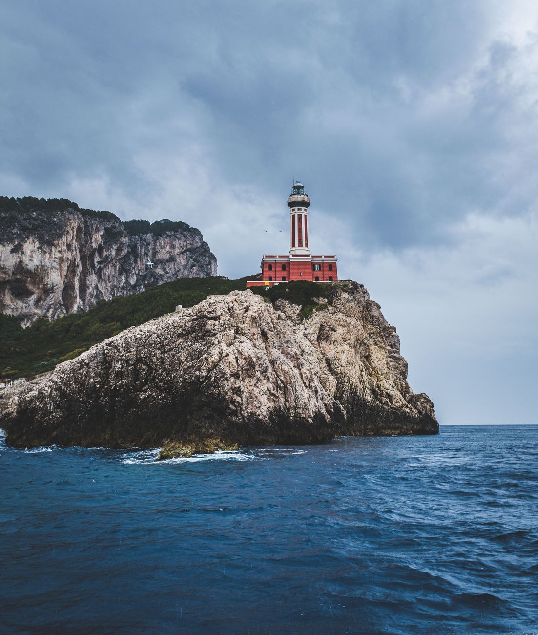 Ein Leuchtturm an der Küste, dessen Licht über das Wasser reicht